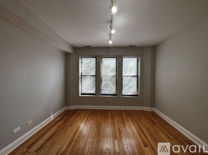 A room with wooden floors and a window with blinds.