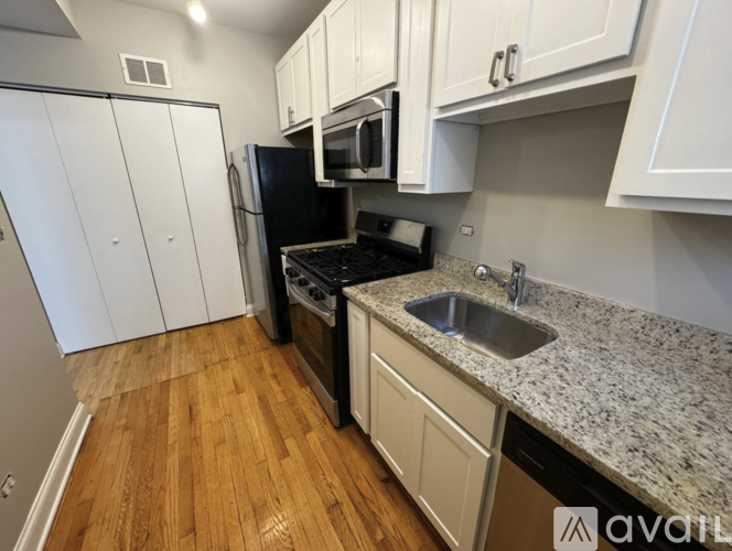 A kitchen with white cabinets and a granite countertop.