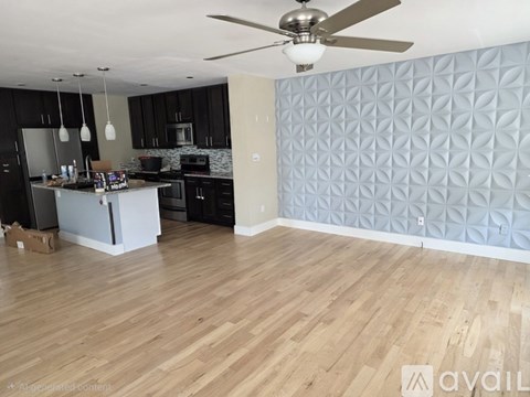 A kitchen with a wooden floor and a ceiling fan.