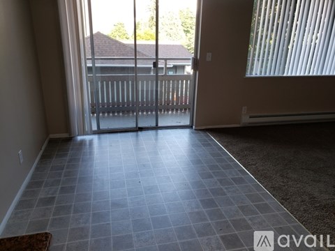 A room with a tiled floor and sliding glass doors leading to a balcony.