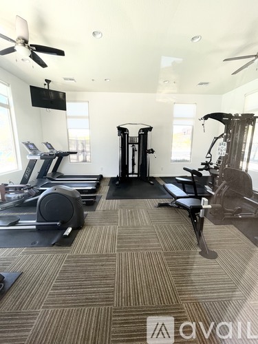 A gym with treadmills, elliptical machines, and a weight machine.