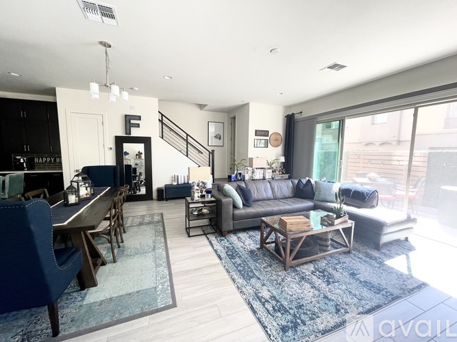 A living room with a blue rug and a wooden coffee table.