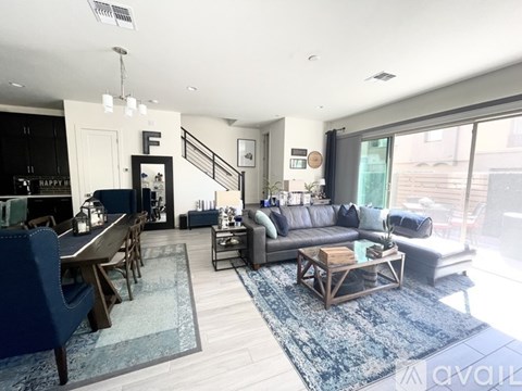 A living room with a blue rug and a wooden coffee table.