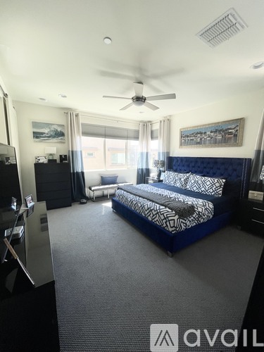 A bedroom with a bed, dresser, and a ceiling fan.