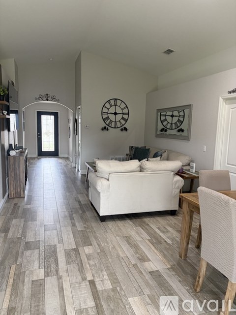 A living room with a white couch and a wooden table.