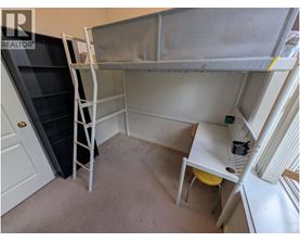 A small room with a bunk bed and a desk.