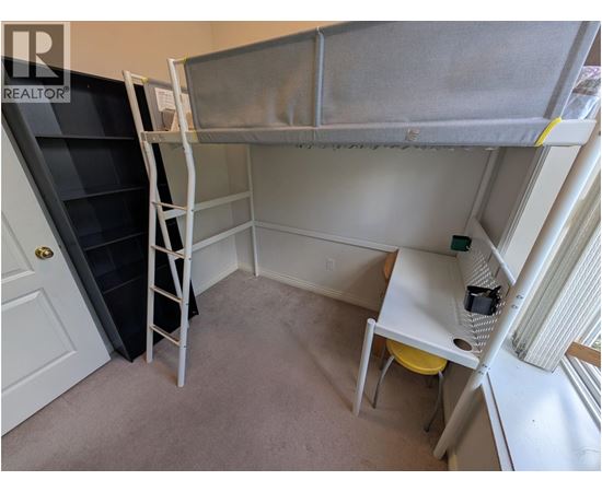 A small room with a bunk bed and a desk.