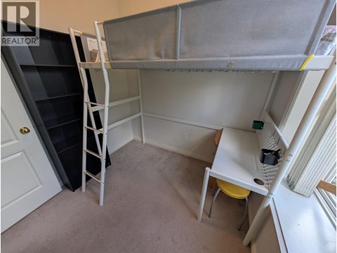 A small room with a bunk bed and a desk.