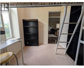 A room with a ladder and a desk.