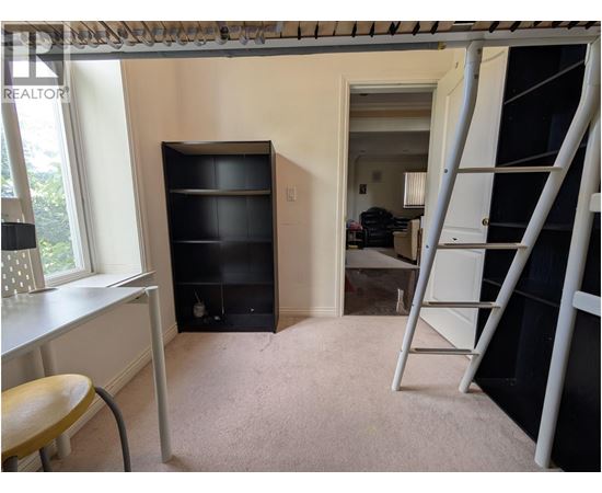 A room with a ladder and a desk.
