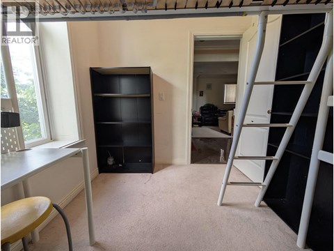 A room with a ladder and a desk.