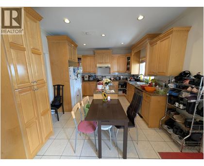 A kitchen with wooden cabinets and a table with chairs.