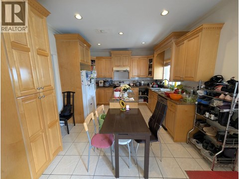 A kitchen with wooden cabinets and a table with chairs.