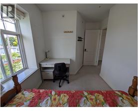A bedroom with a bed, desk, and chair.