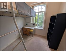 A bedroom with a bunk bed and a desk with a window.