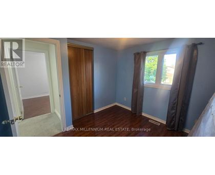 A bedroom with a window and a wooden door.
