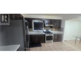 A kitchen with a refrigerator and a sink.
