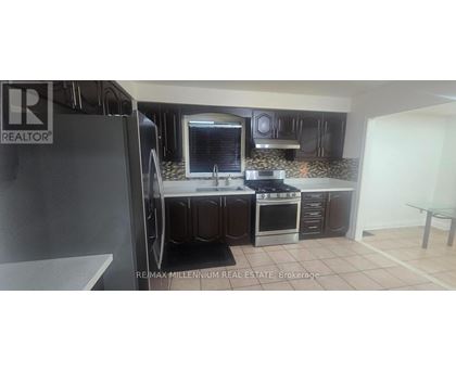 A kitchen with a refrigerator and a sink.