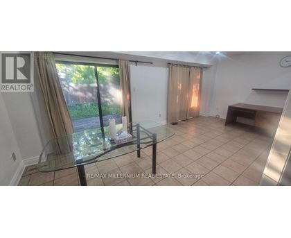A glass table is in a white room with a sliding glass door.