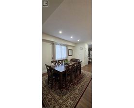 A dining room with a large table and chairs.