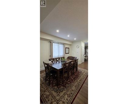 A dining room with a large table and chairs.