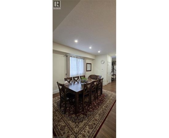 A dining room with a large table and chairs.