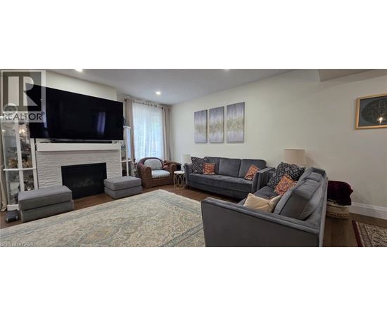 A living room with a grey couch and a fireplace.