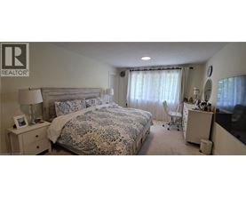 A bedroom with a large bed and a desk with a chair.