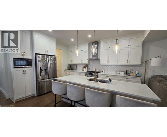 A modern kitchen with a center island and a refrigerator with a water dispenser.