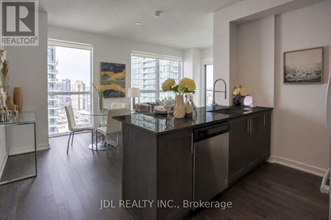 A modern kitchen with dark wood floors and a large island.
