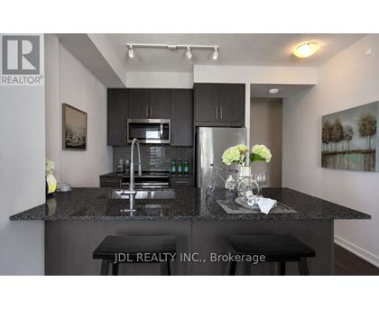 A modern kitchen with granite countertops and stainless steel appliances.