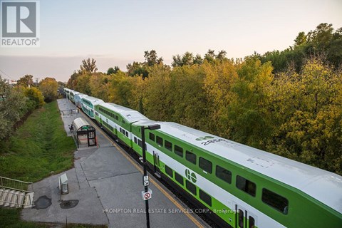 A green and white train is parked at a station.