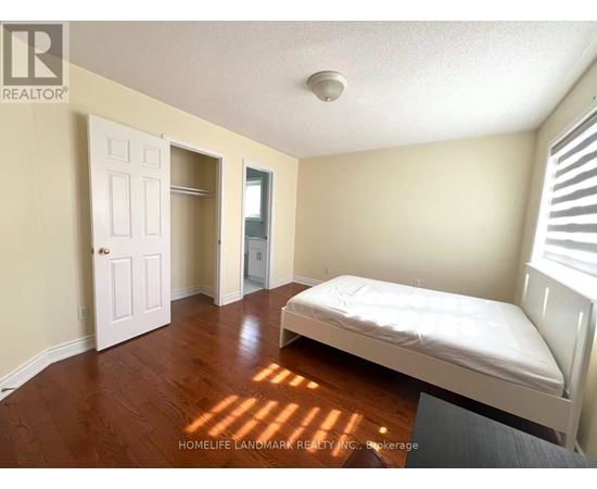 A bedroom with a bed, dresser, and closet.