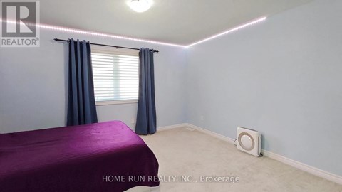A bedroom with a purple bedspread and a window with blue curtains.