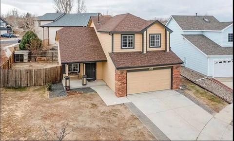 A house with a brown roof and a garage door.
