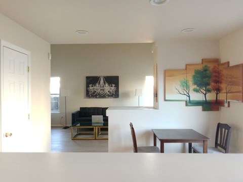 A living room with a couch, chair, and painting on the wall.