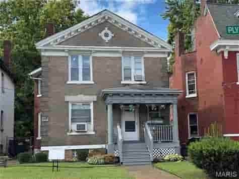A brown house with a white door and windows.