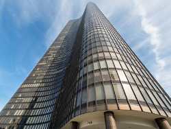 A tall building with a glass facade and a curved base.