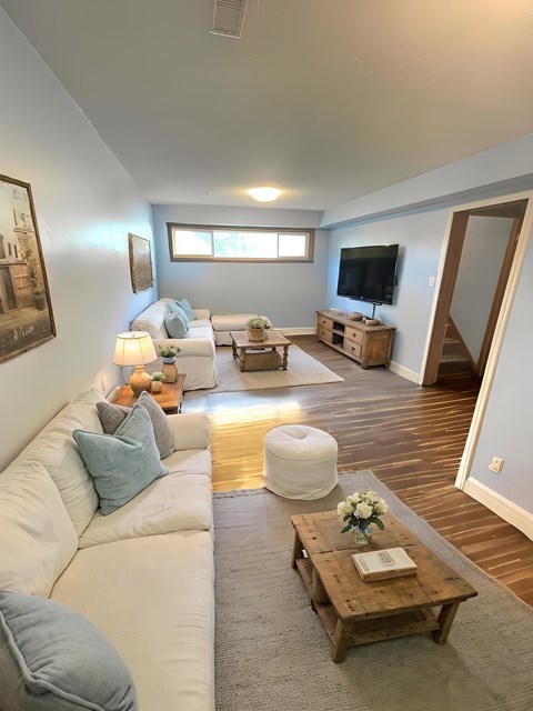 A living room with a white couch and a wooden coffee table.