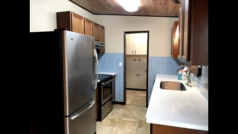 A kitchen with a stainless steel refrigerator and a sink.