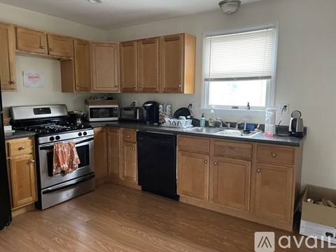 A kitchen with wooden cabinets and black appliances.