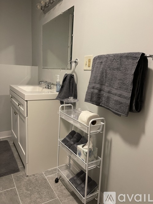 A bathroom with a sink, mirror, and towel rack.