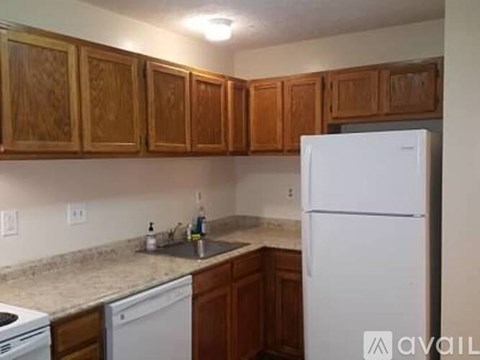A kitchen with wooden cabinets and a white refrigerator.
