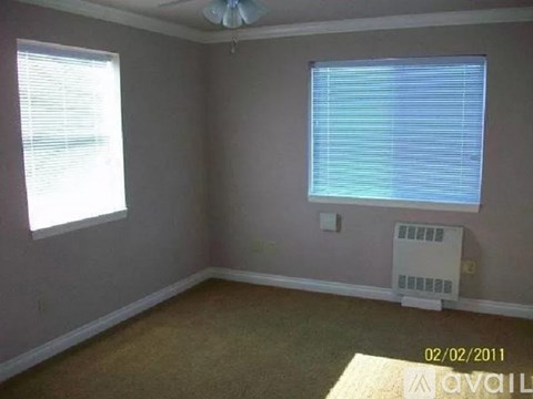 A room with a window and a fan on the ceiling.