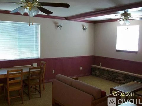 A living room with a couch, chairs, and a dining table.