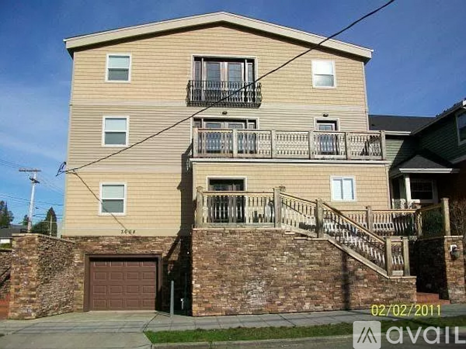 A two-story building with a balcony and a garage.