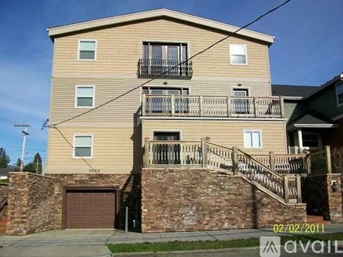 A two-story building with a balcony and a garage.