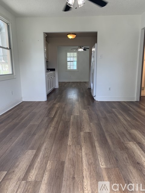 A room with wooden flooring and a ceiling fan.
