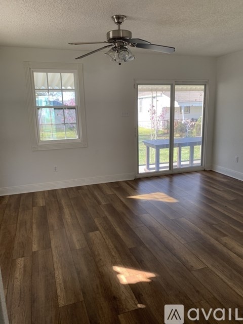 A room with wooden flooring and a ceiling fan.