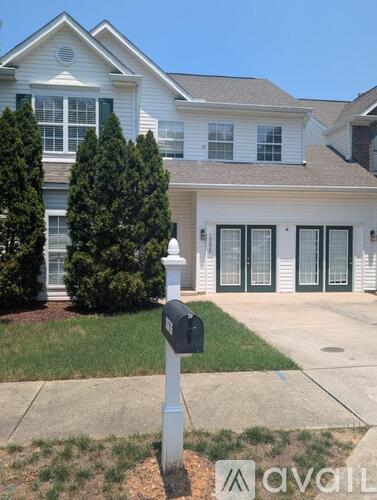 A white house with a mailbox in front.